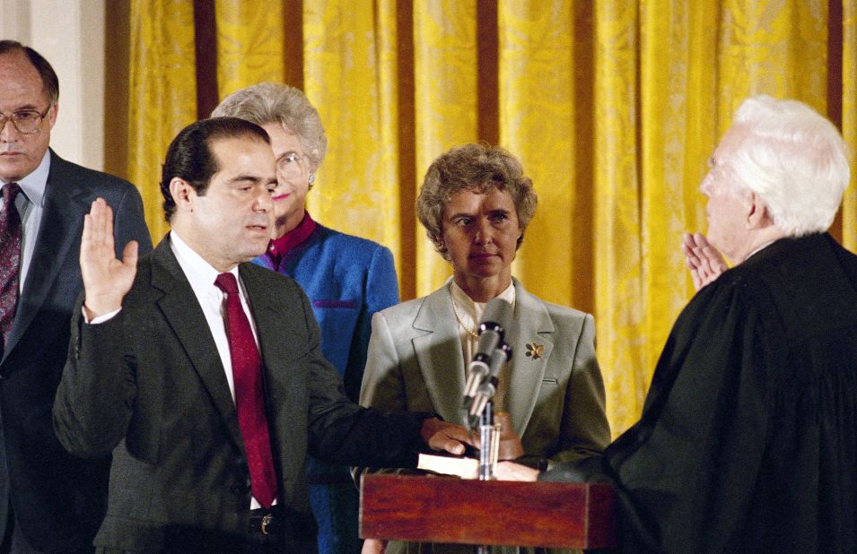 Retiring Chief Justice Warren Burger, right, administers the oath to Scalia, as Scalia's wife, Maureen, holds the Bible on September 26, 1986. Scalia was the 103rd person to sit on the court. 