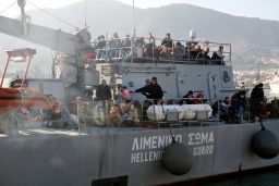 Migrants arrive on a Hellenic coast guard ship at a Lesbos Island port.
