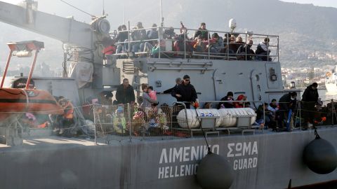 Migrants arrive on a Hellenic coast guard ship at a Lesbos Island port.