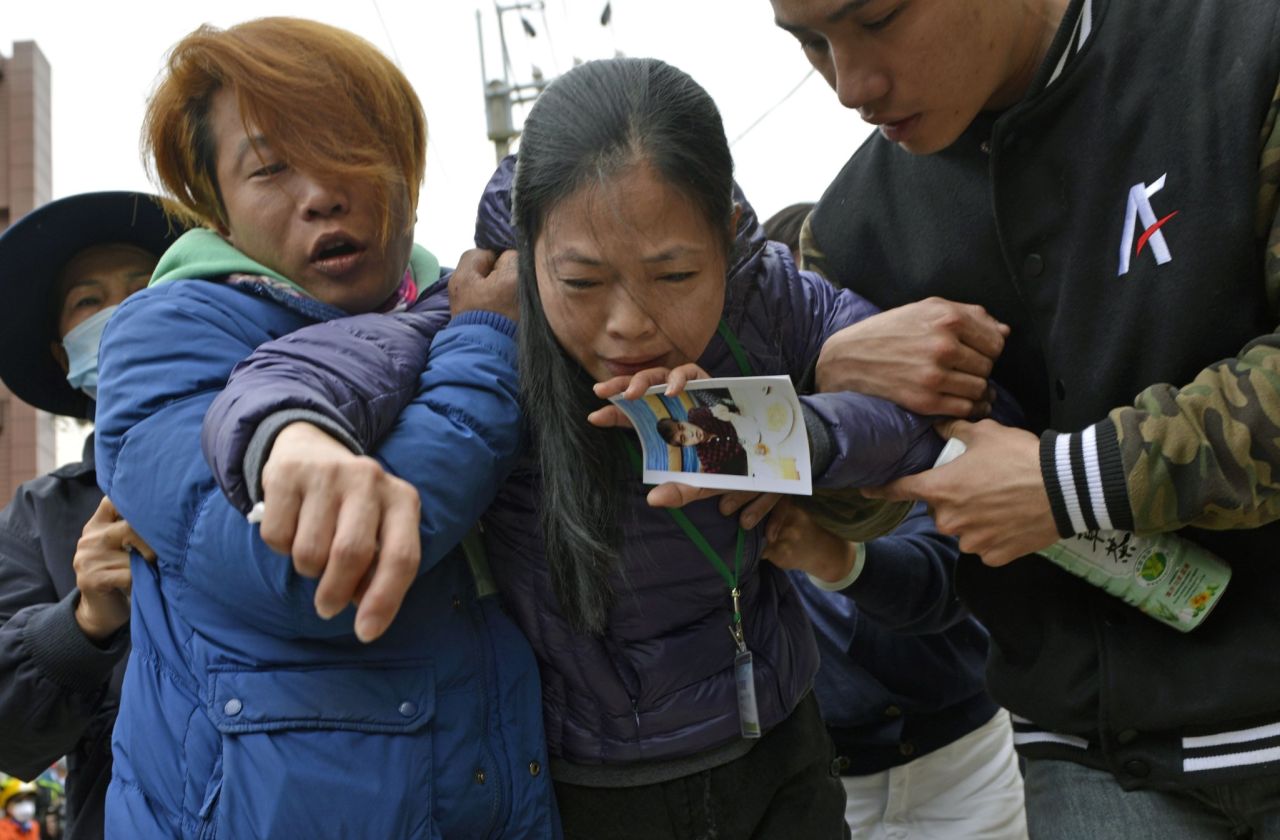 A mother holds a picture of her son after a male body was recovered on February 10. 