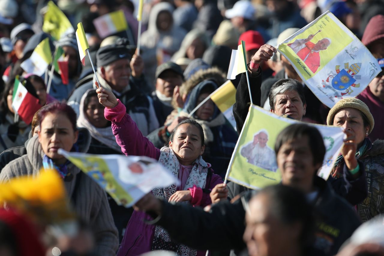 Pilgrims wave flags as they wait for Pope Francis to arrive in Ecatepec on February 14. 