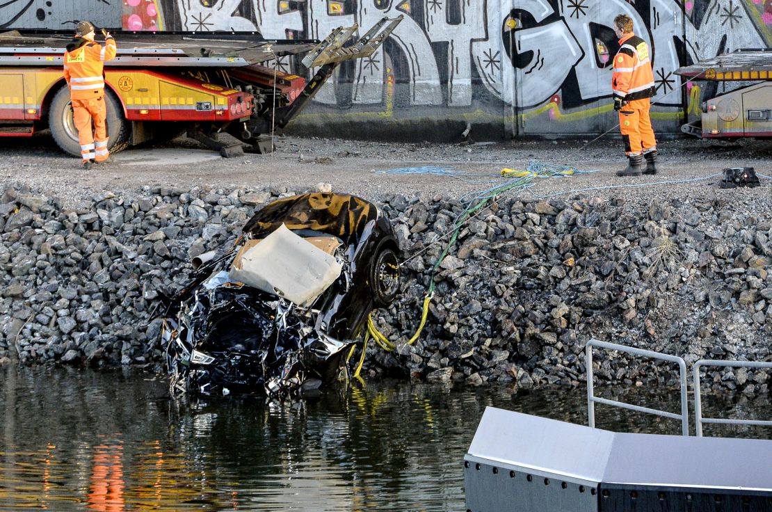 A damaged car is pulled from a canal in Sodertalje, Sweden, on Saturday.