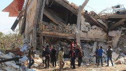 People gather around the rubble of a hospital supported by Doctors Without Borders (MSF) near Maaret al-Numan, in Syria's northern province of Idlib, on February 15, 2016, after the building was hit by suspected Russian air strikes. 