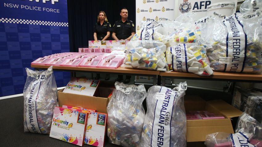 Officers stand by a display of confiscated drugs in Sydney, Monday, Jan. 15, 2016. Australian Federal Police said they had seized 720 liters (190 gallons) of the illicit drug methylamphetamine worth more than 1 billion Australian dollars ($700 million). (AP Photo/Rick Rycroft)
