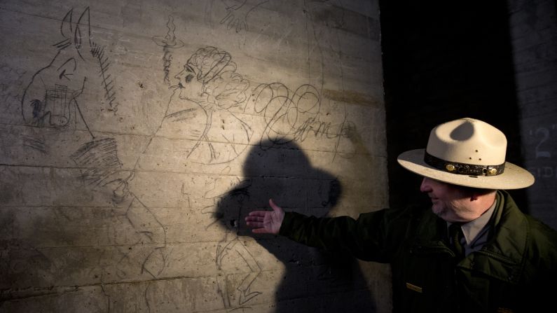Sean Kennealy of the National Park Service points out drawings on a concrete pillar Monday, February 15. The renovation will include providing visitors with a look at graffiti left by construction workers building the monument.
