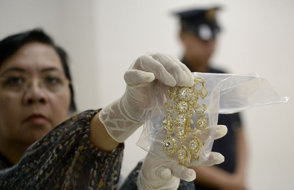 An agency official displays a diamond-studded piece of jewelery from the collection. Imelda Marcos was renowned for her lavish spending during her husband's time in power.