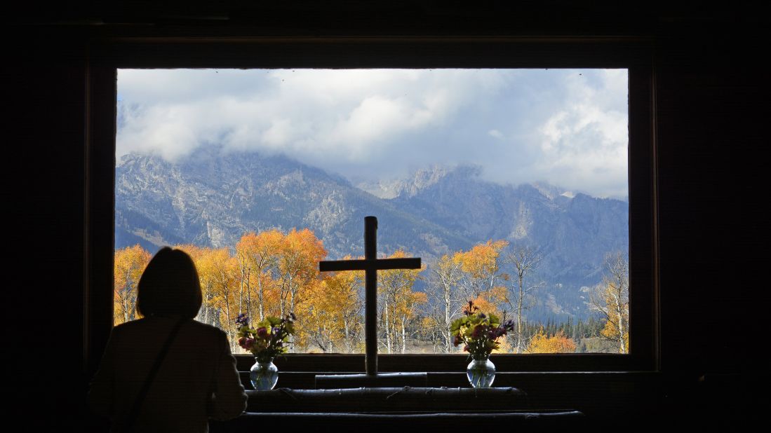  A park visitor takes in the autumn view from the alter window at the Chapel of Transfiguration in <a href="http://www.cnn.com/2013/05/30/travel/national-parks-grand-teton/">Grand Teton National Park</a> in Wyoming. A nearby Episcopal church built the chapel in 1925 to serve nearby guests and dude ranch workers, before the area became a national park. 