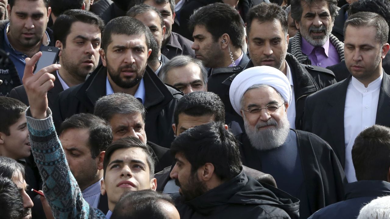 A man takes a selfie Thursday, February 11, as Iranian President Hassan Rouhani -- wearing the white turban -- attends a rally commemorating the anniversary of the Iranian revolution.