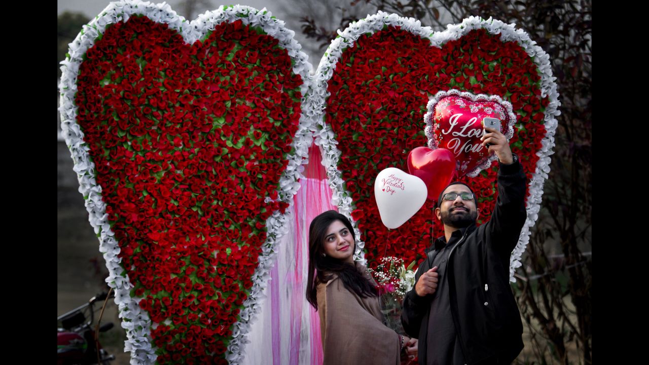 A couple takes a selfie in front of a heart-shaped bouquet display in Islamabad, Pakistan, on Valentine's Day.