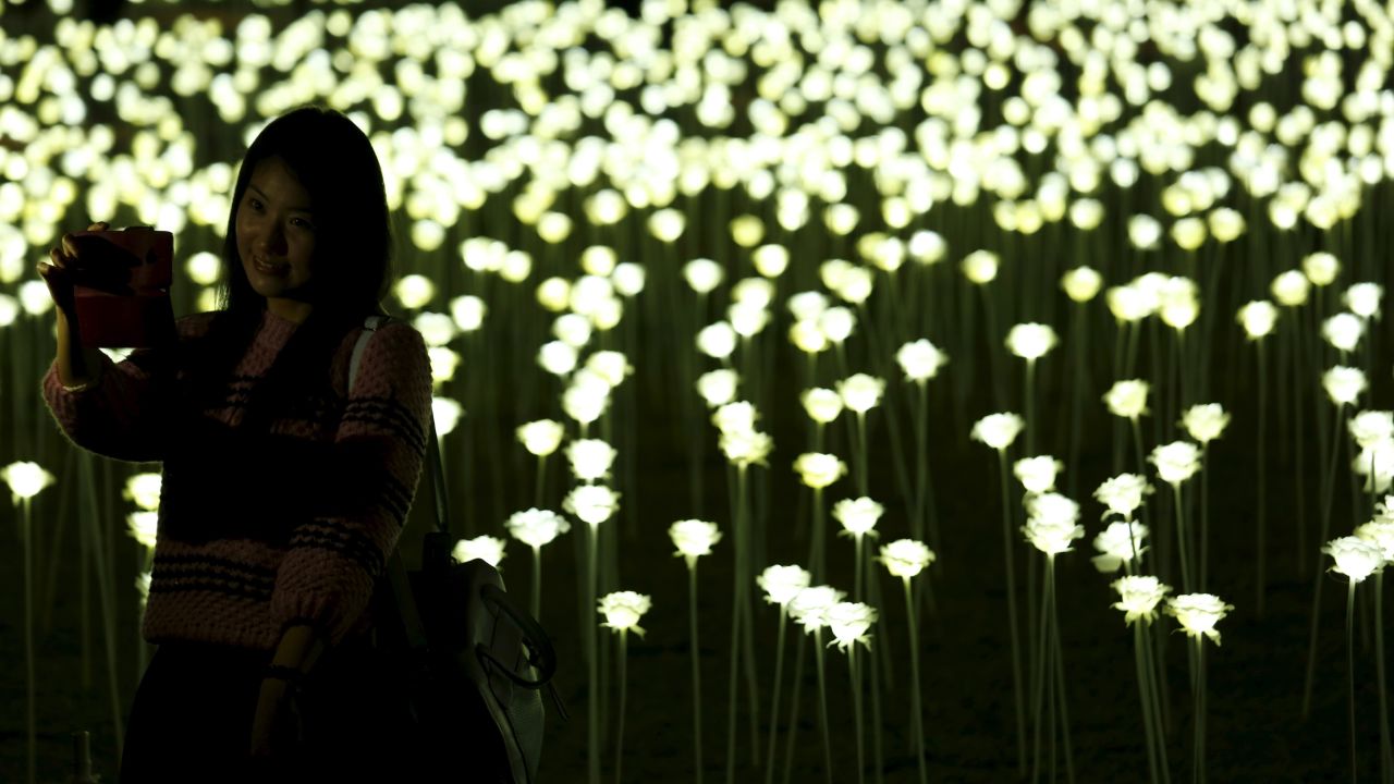 A woman in Hong Kong takes a selfie in front of LED lights shaped like white roses on Saturday, February 13. <a href="http://www.cnn.com/2016/02/10/living/gallery/look-at-me-selfies-0210/index.html" target="_blank">See 20 selfies from last week</a>