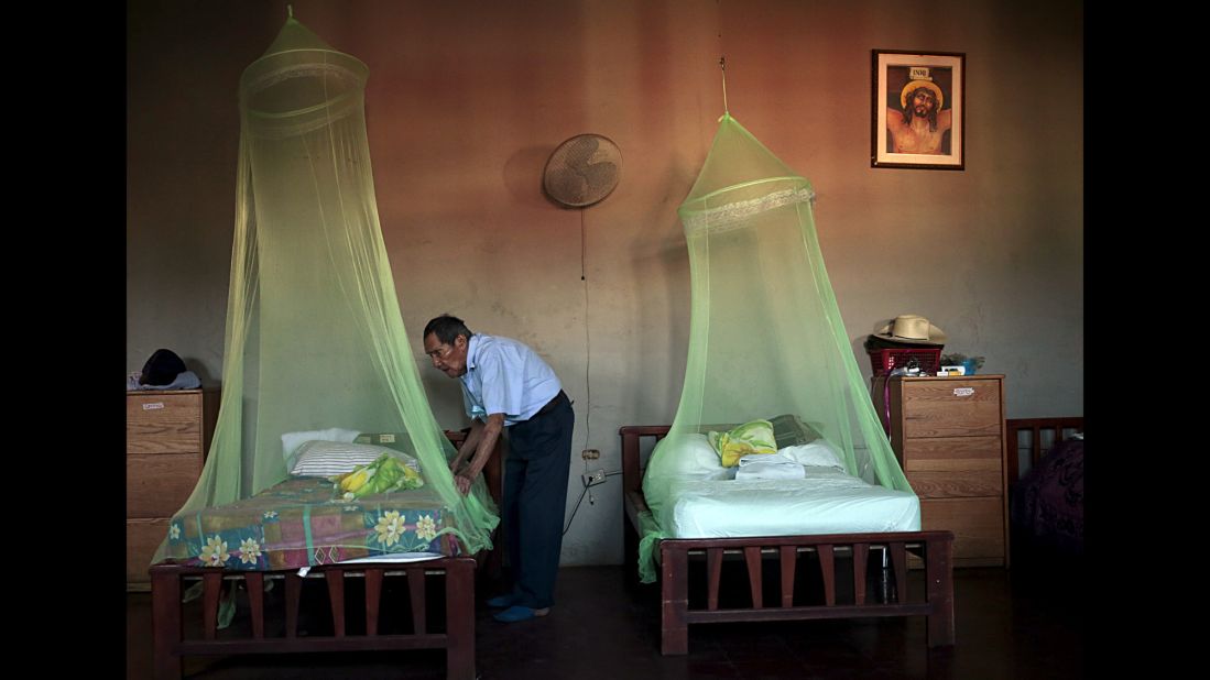 A man places a mosquito net over a bed at a home for the elderly in Masaya, Nicaragua, on Thursday, February 11.