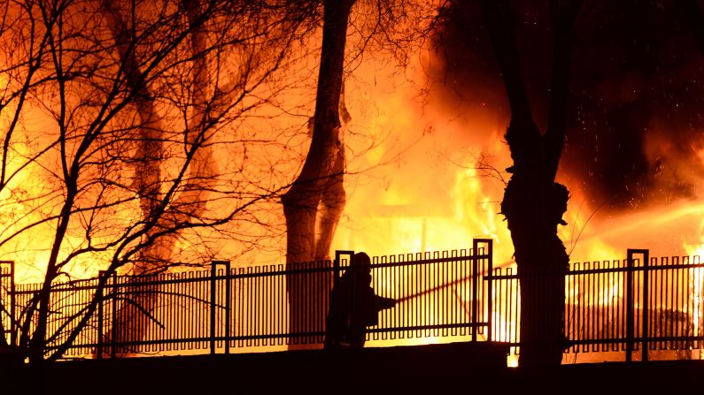 A firefighter tries to put out the blaze.