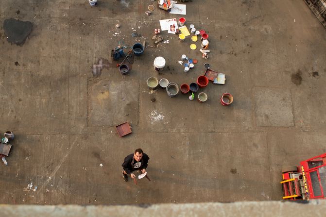 Borondo at work at the Inland Container Depot. <br />The containers deliver fruits and vegetables around India and will go back to their duties in their new painted forms, bringing art to the rest of the subcontinent. <em>(Photograph by Shijo George)</em><br /> 