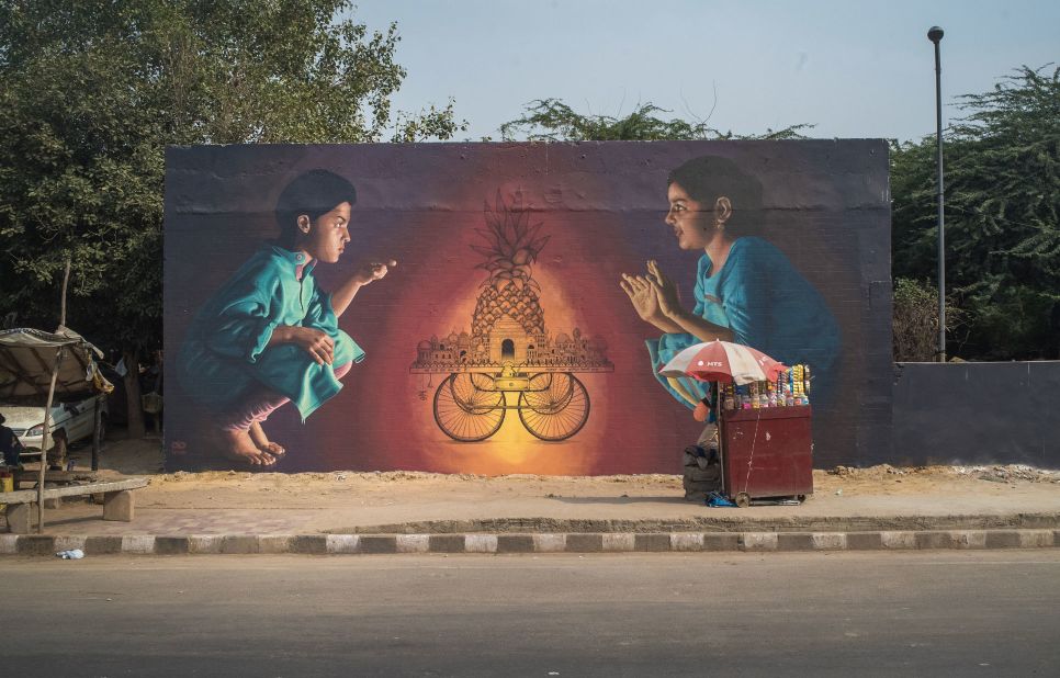 After painting this mural, the trio left a small token of gratitude for the tea vendor who has a stall next to the wall. With the help of Shabbu, a sign painter in Delhi, they wrote "This cart belongs to Chote Lal" on the cart depicted by the mural in Hindi typography. <em>(Photograph by Akshat Nauriyal)</em>