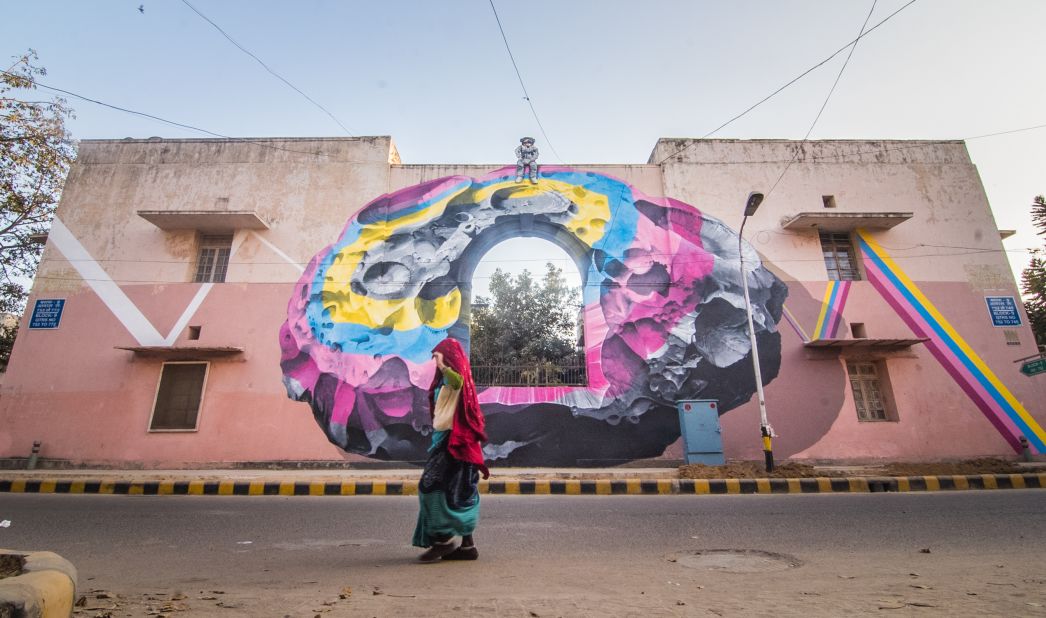Nevercrew is a Swiss duo whose work examines the human condition, especially the relationship between mankind and nature. They've painted a colorful meteorite with an astronaut on top of the wall to serve as a metaphor for someone who can see things from a different perspective. <em>(Photograph by Akshat Nauriyal)</em>