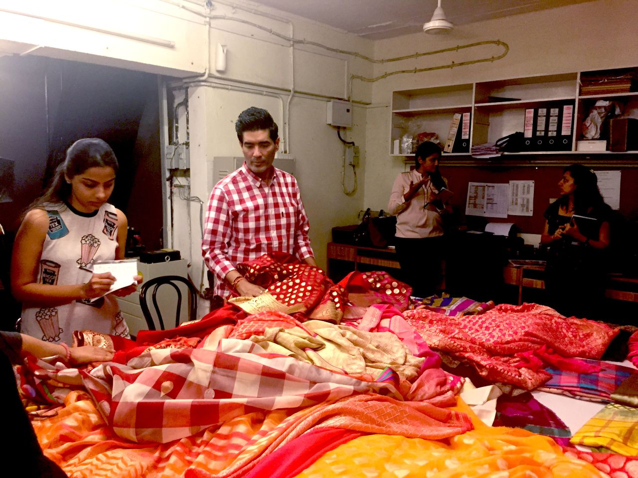 Manish Malhotra inspects saris from his "Regal Threads" line in his Mumbai store's basement.