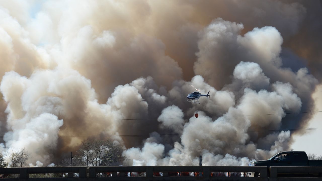 A helicopter helps fight a fire on a train trestle near the Bonnet Carre Spillway, west of New Orleans, on Saturday, February 13. The cause of the fire is under investigation.