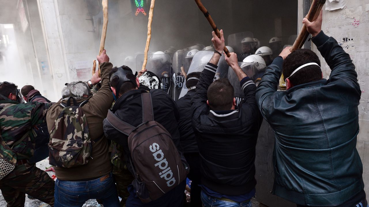 Farmers clash with police officers blocking the entrance of the Agriculture Ministry in Athens, Greece, during a demonstration against pension reform on Friday, February 12.
