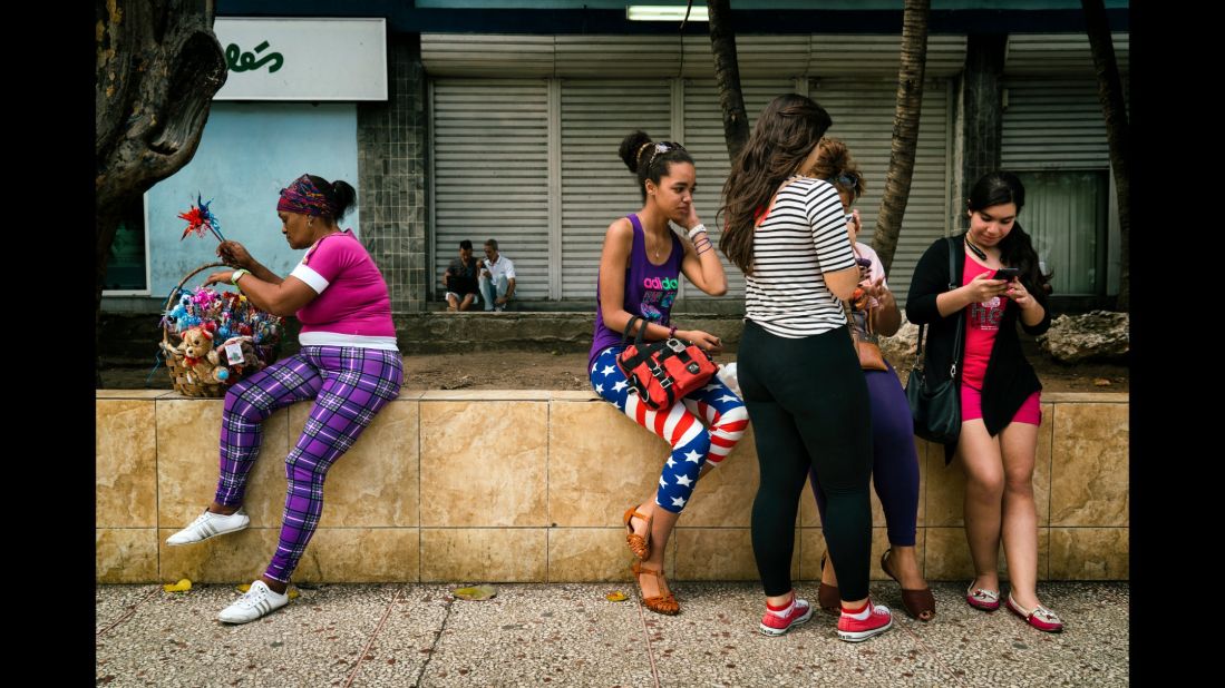 Girls use smartphones in Havana. 