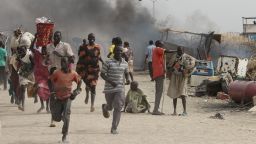 TOPSHOT - South Sudanese civilians flee fighting in an United Nations base in the northeastern town of Malakal on February 18, 2016, where gunmen opened fire on civilians sheltering inside killing at least five people.Gunfire broke out in the base in Malakal in the northeast Upper Nile region on February 17, 2016 night, with clashes continuing on Thursday morning that left large plumes of smoke rising from burning tents in the camp which houses over 47,000 civilians. / AFP / Justin LYNCH        (Photo credit should read JUSTIN LYNCH/AFP/Getty Images)