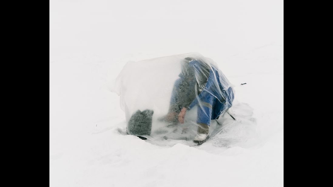 A fisherman covers himself with a plastic bag to shield himself from the wind and cold in Astana, Kazakhstan.