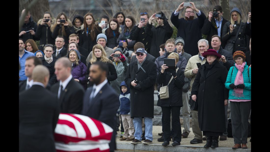People watch as Scalia's casket is carried toward the Supreme Court building.
