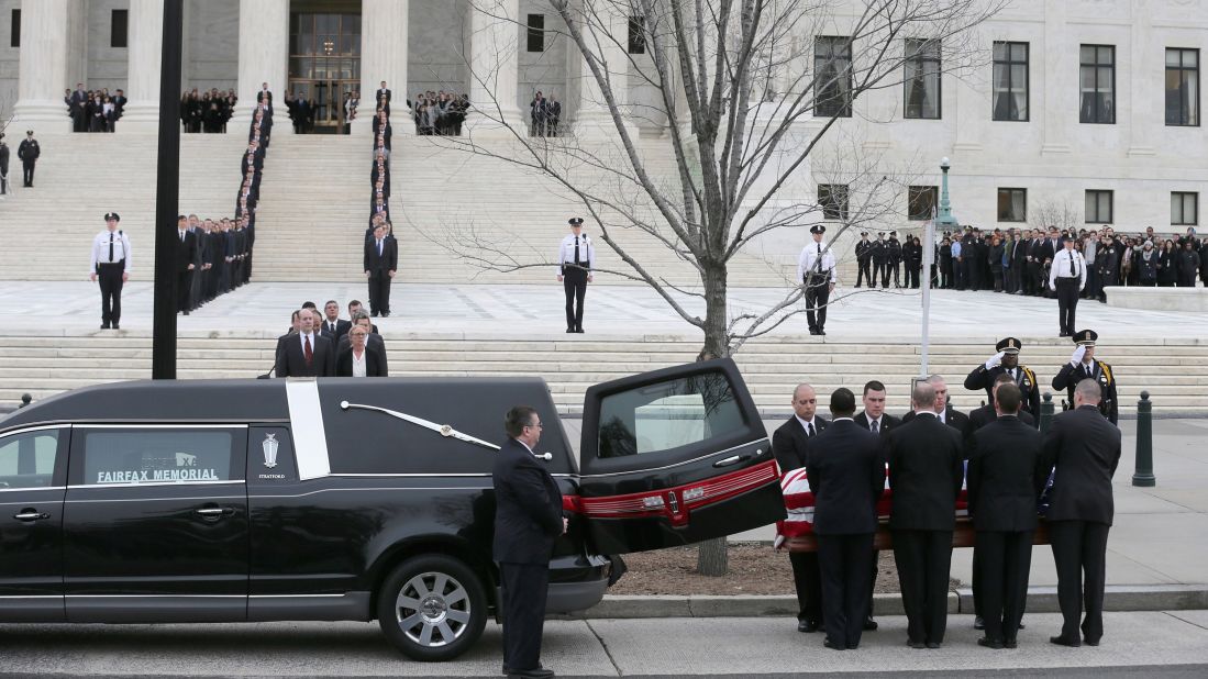 The pallbearers unload Scalia's casket from a hearse.
