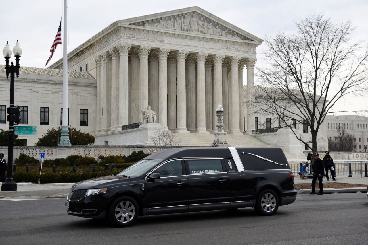 A hearse carrying the casket departs the U.S. Supreme Court Building on February 20.
