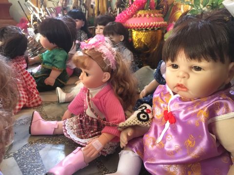 Dolls line of the floor of the Sawang Ar-rom Temple in Bangkok. They've been left there by former owners who once treated them like real children.