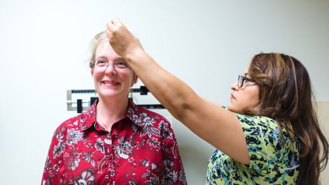 Eileen Bachemin, 50, gets her height measured during a physical exam.