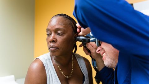 Tracy Young, 50, gets her ears checked by Brian Schlesinger, a physician's assistant, during her physical exam.