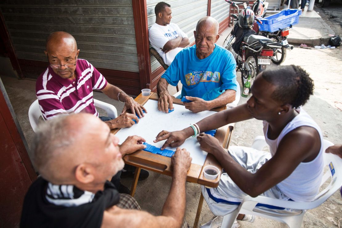 Men play dominoes on the sidewalk of Santo Domingo's Little Haiti neighborhood.