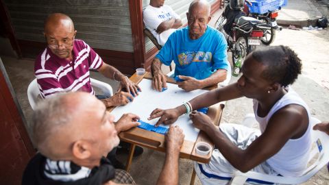 Men play dominoes on the sidewalk of Santo Domingo's Little Haiti neighborhood.