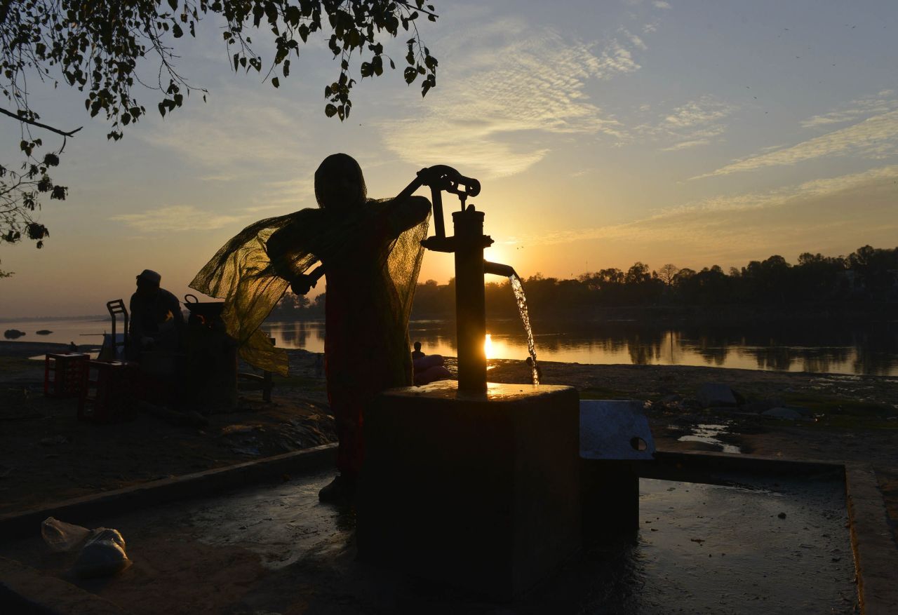 A girl fills a can with water from a hand pump in a slum area of Lahore, Pakistan. "More than 1 billion people without energy spend a significant portion of their time collecting wood and water for the basics of life," according to the Gateses.