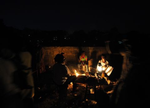 Women cook by an open flame in a slum near Nairobi, Kenya. "Without access to energy, the poor are stuck in the dark, denied all of the economic, social and health benefits that come with power," say the Gateses.