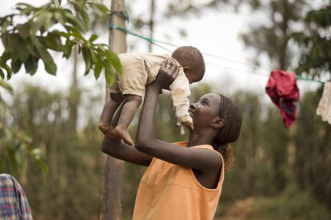 A mother holds her child in Mwea Village, Kenya. "Women are so busy meeting basic needs that they can't invest in the future by doing paid work, going to school, or visiting the doctor regularly," Bill and Melinda Gates say in a recent CNN op-ed.