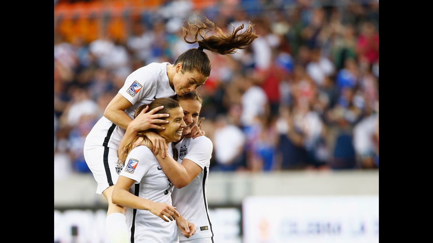 U.S. soccer players Kelley O'Hara, top, and Lindsey Horan, right, congratulate Tobin Heath after Heath scored a second-half goal against Canada on Sunday, February 21. The United States defeated Canada 2-0 to win the final of the CONCACAF tournament in Houston.