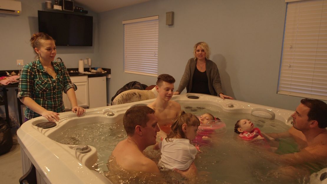 Angelina Aramburu and Gwen Hartley watch their families enjoy a hot tub.