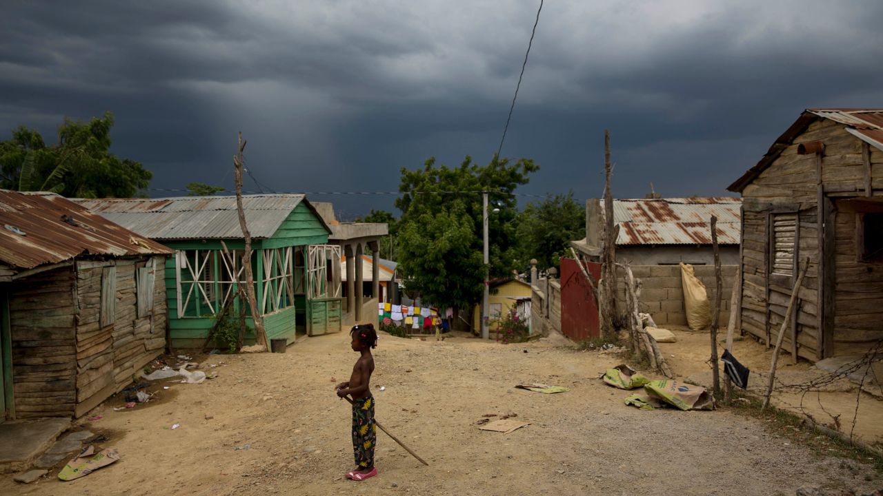 A daughter of Haitian immigrants stands at a crossroads in Esperanza, Dominican Republic.
