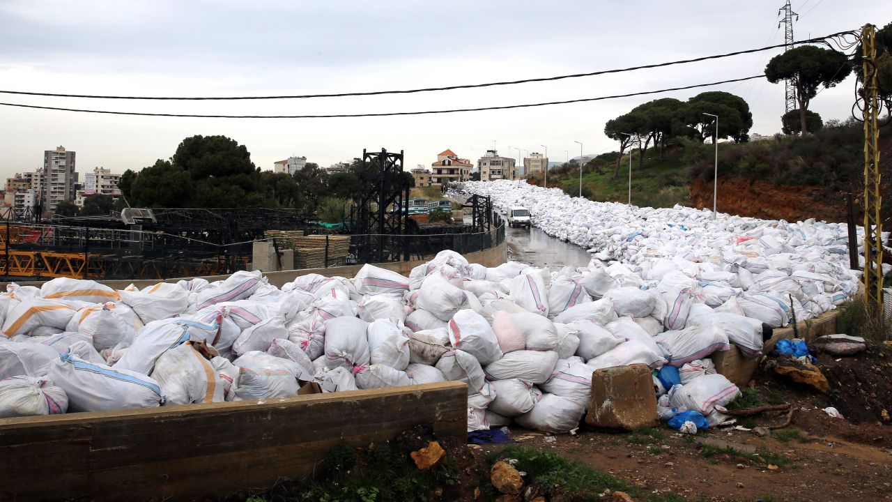 A van drives past piles of garbage blocking a newly opened road in the town of Jdeideh, northeast of Beirut, on January 4.