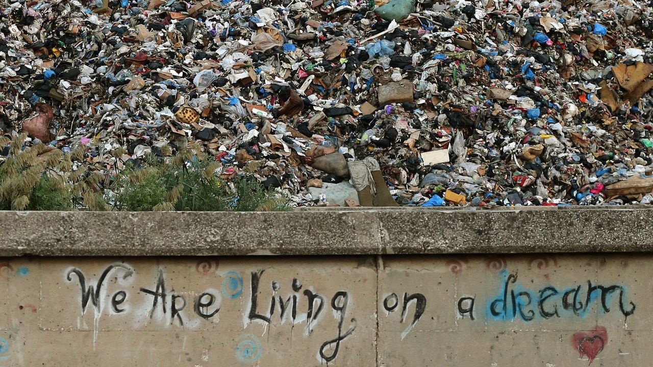 Graffiti on a concrete wall in front of a pile of garbage in Beirut on October 17 reads, "We are living on a dream."