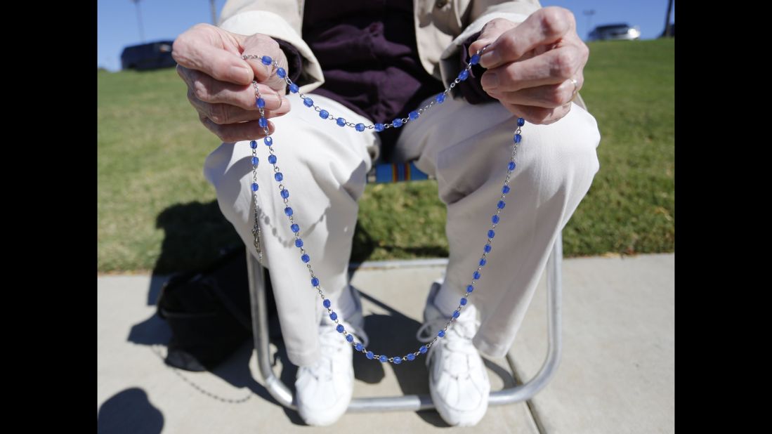 Three days later, on October 31, 2013, the U.S. 5th Circuit Court of Appeals reversed the federal district judge's decision. Here, a woman holds her rosary beads as she prays on the sidewalk across the street from Planned Parenthood in Fort Worth, Texas.