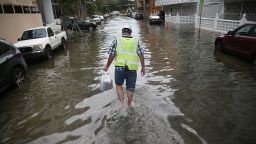 A Miami Beach resident walks through flooded streets in September 2015.