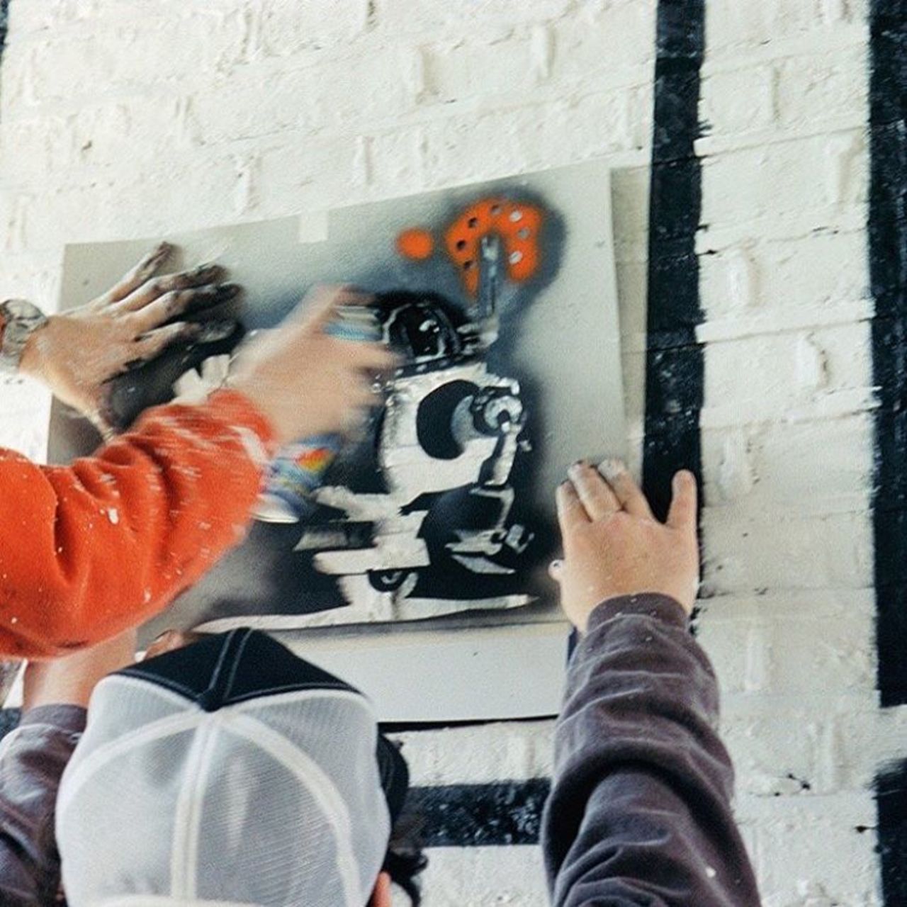 "This is an early picture of Banksy at work, from many years ago, when he was first starting out. Here he was adding to an unofficial street art exhibition in Rivington Street in Shoreditch, while I documented the whole thing with my camera."<br />