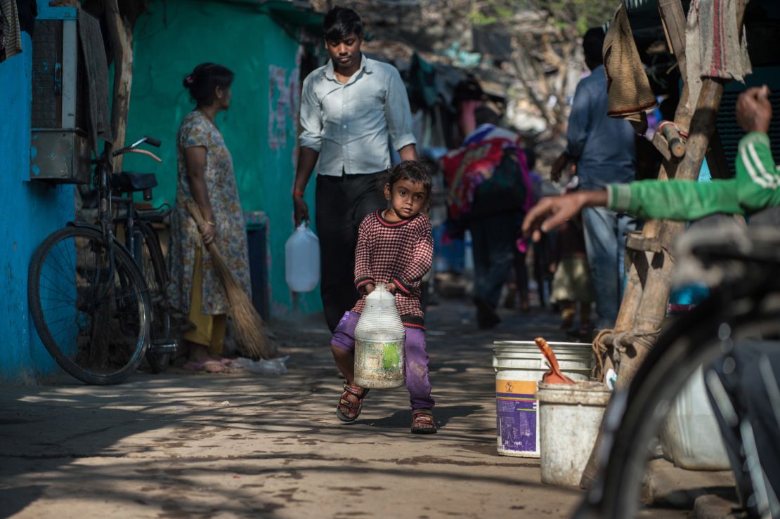 An Indian girl struggles to carry a jerry can filled with water as she helps family members fetch water from a distribution point in the low-income eastern New Delhi neighborhood of Sanjay camp on February 23, 2016. A water crisis in India's capital will take up to two weeks to fix, authorities warned.