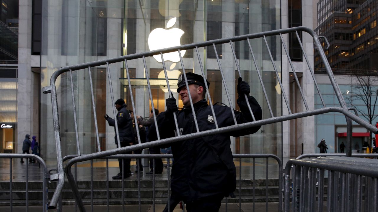 A New York City police officer carries a steel barricade outside an Apple store on Tuesday, February 23. People gathered outside the store to protest the ruling that <a href="http://money.cnn.com/2016/02/17/technology/fbi-apple-hack-iphone/index.html" target="_blank">Apple must help the FBI</a> break into the phone of Syed Farook, one of the shooters in the December 2015 terrorist attack in San Bernardino, California. Apple has argued that coding a "back door" into the iPhone would compromise the security of hundreds of millions of its customers. The matter is now tied up in court, and <a href="http://money.cnn.com/2016/02/24/news/companies/apple-tim-cook-abc-interview/index.html" target="_blank">it has put Apple CEO Tim Cook in the spotlight</a> of a tense national debate about balancing security with privacy.
