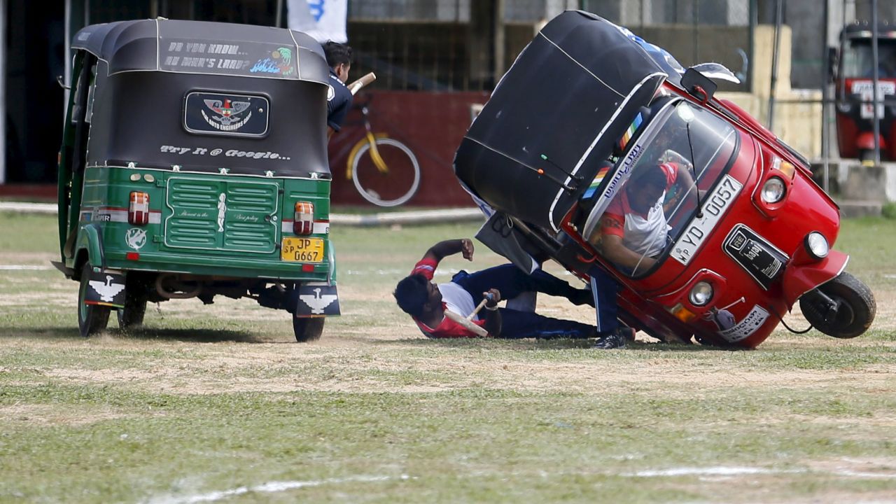 A competitor falls out of his "tuk tuk," a three-wheeled vehicle, during a polo game in Galle, Sri Lanka, on Sunday, February 21.