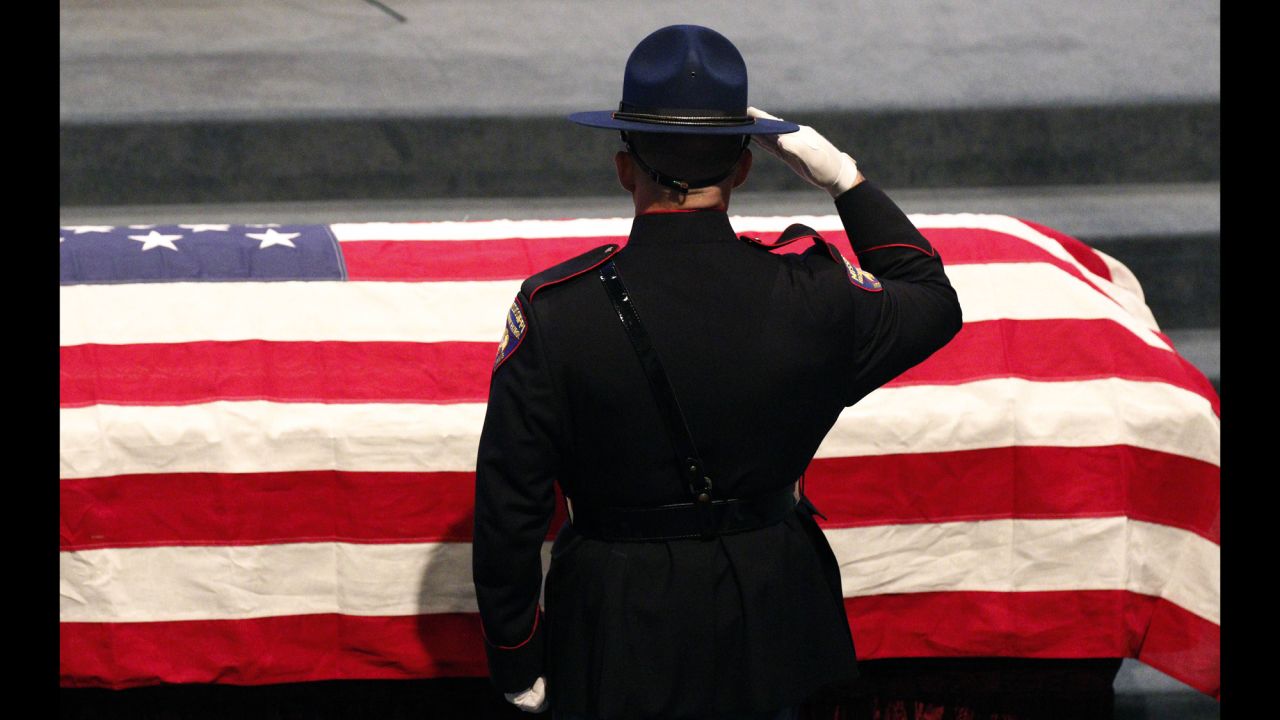 A member of the Mississippi Highway Patrol Honor Guard salutes the casket of James Lee Tartt prior to his funeral service in Grenada, Mississippi, on Tuesday, February 23. Tartt, an agent with the Mississippi Bureau of Narcotics, was fatally shot in a standoff with a suspect.