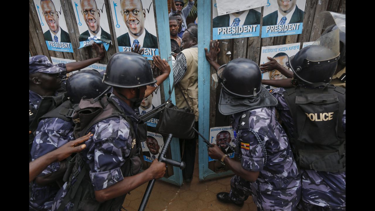 Riot police officers in Kampala, Uganda, try to lock supporters of Kizza Besigye inside the presidential candidate's party headquarters on Friday, February 19. Police stormed the headquarters and put Besigye and six officials from his party under "preventative arrest," they said. Authorities <a href="http://www.cnn.com/2016/02/20/africa/uganda-election/" target="_blank">detained the officials</a> because they planned to announce unauthorized results tallied by the opposition, police spokesman Patrick Onyango said. Under law, only election officials may announce results, he said. Preliminary figures showed Besigye had lost the election to incumbent Yoweri Museveni, but Besigye's party rejected the results and demanded an independent audit.