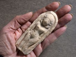 The figurine was made by pressing clay into a mold.